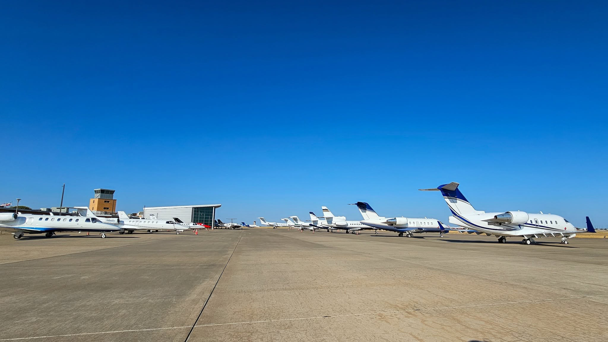 variety of jets parked on the LBB ramp under a bright blue sky