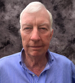 Headshot of Doug Lacey in blue shirt in front of professional background